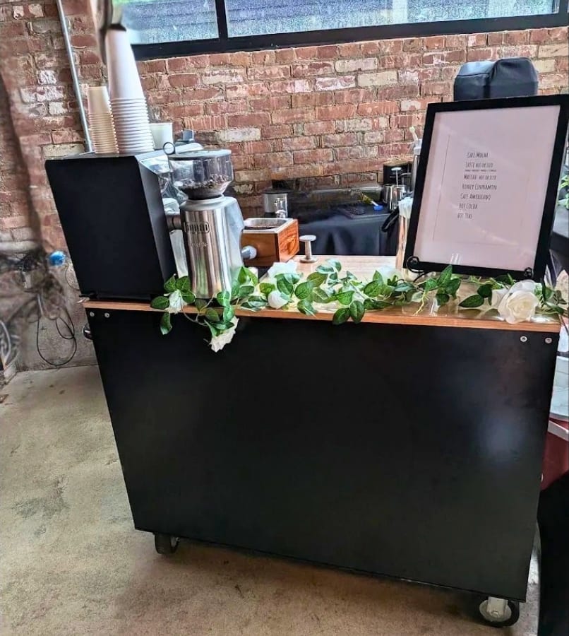 Coffee cart trimmed with greenery for an outdoor event